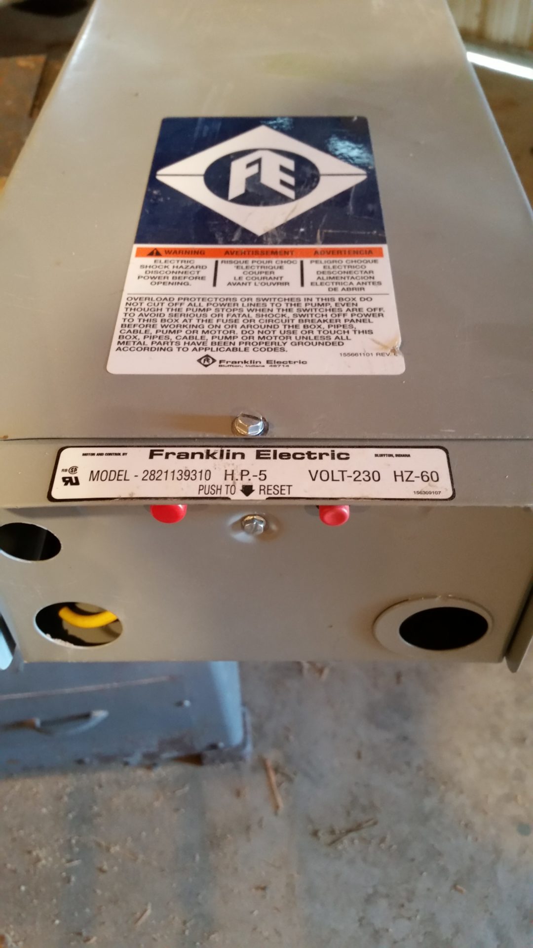 Close-up of external red overload reset buttons and a control box HP label